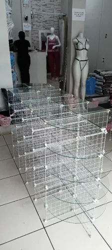 Balcão aramada com prateleiras de vidro.