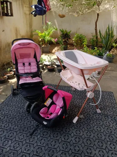 Bebê conforto, carrinho de bebê e banheira com suporte.