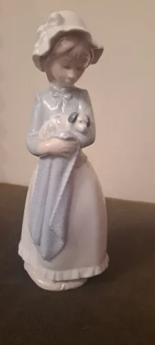 Nao por Lladro, Menina segurando um cachorrinho dormindo em um cobertor azul