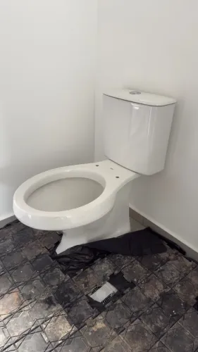 Vaso sanitário em louça branca com caixa acoplada.