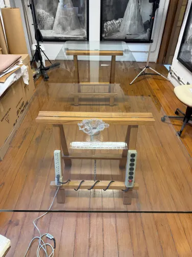 Mesa de vidro temperado com pés de cavaletes de madeira
