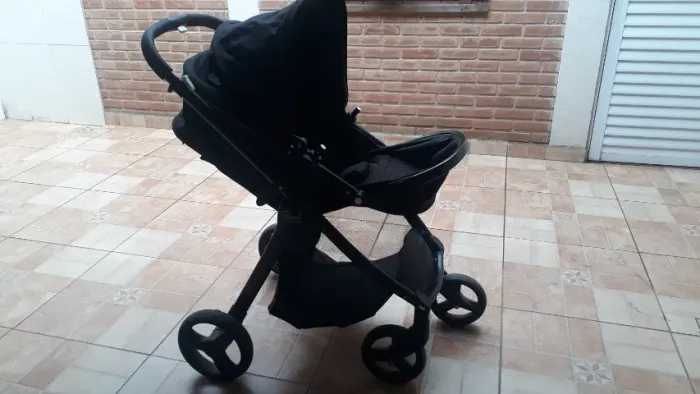 Carrinho de bebê com bebê conforto e base