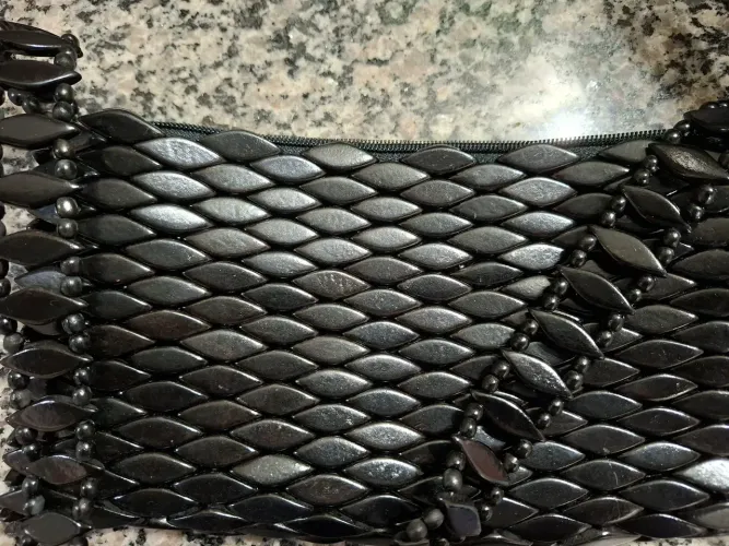 Bolsa artesanal em madeira preta.