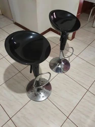 Banqueta alta giratória modelo "Tulipa", com assento em plástico ABS preto e base metal.