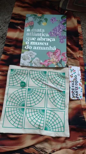 Sacola com livro comemorativo de 10 anos do museu do Amanhã.