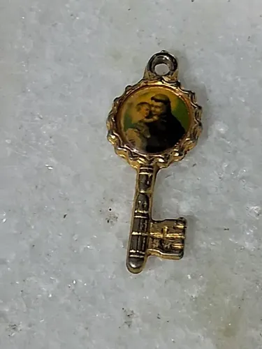 Pingente é de Santo Antônio de Pádua com o Menino Jesus em formato de chave