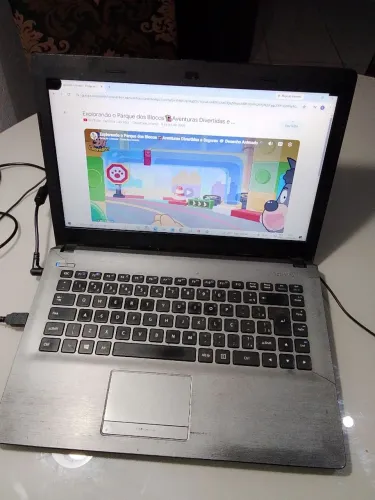 Notebook funcionando com pequenas avarias na carcaça e na tela
