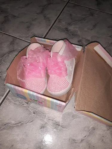 Sapatinho infantil delicado com pérolas e laço rosa