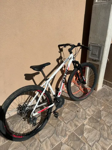 Vendo bicicleta CALOI GTS Vulcan branca com detalhes em vermelho e preto.