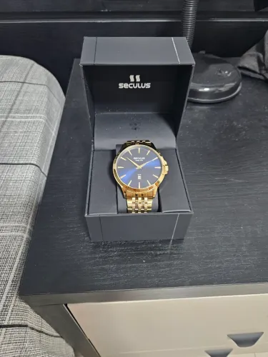 Relógio Secculus dourado com fundo azul