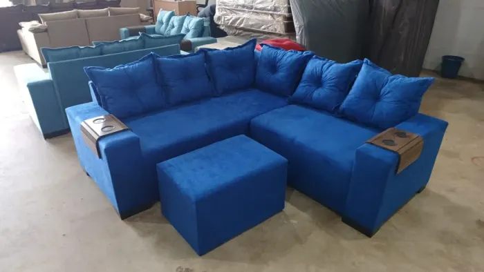Sofá de canto azul com puff e porta-copos