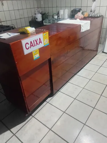 Balcão de madeira rústico para comércio com o caixa.