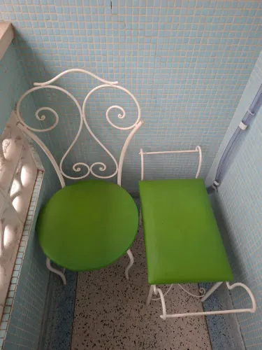Conjunto 2 cadeiras de ferro trabalhadas com assento verde.
