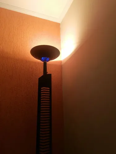 Luminária de chão alta, com porta-CD integrado, de estilo mais antigo/vintage.