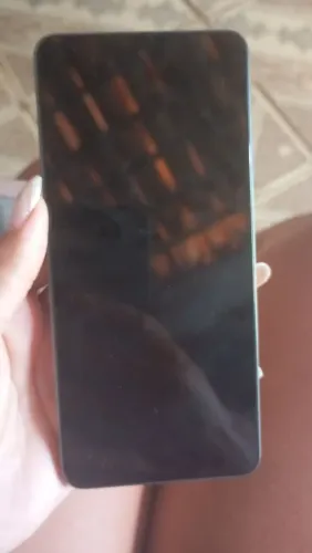 Celular Realme c67, com água na tela.