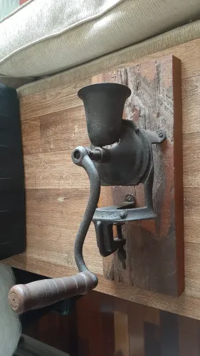 Antigo moedor manual de café e grãos, marca Cruzeiro ,fixado a uma base de madeira rustica