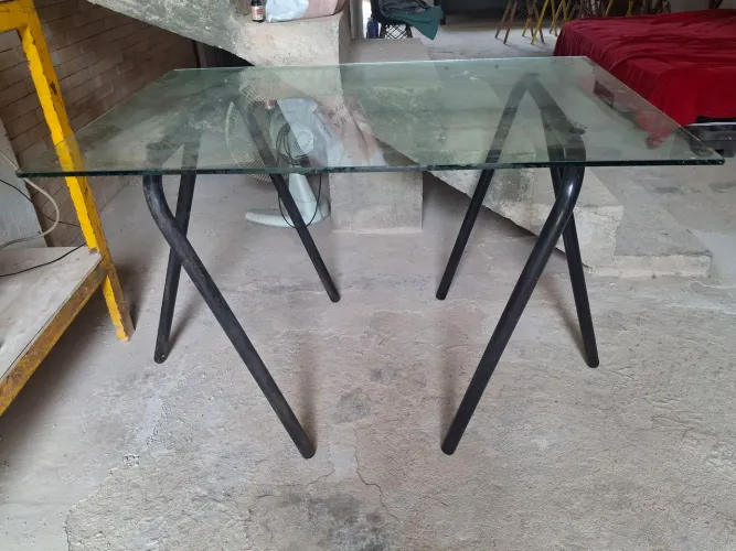 Mesa de vidro e pés cavaletes de ferro