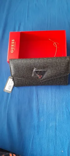Carteira Guess na cor marrom com estampa de monograma da marca. Divisão para cartões e R$.