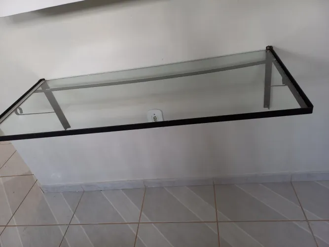 Venda de uma bancada em vidro com armação de ferro.
