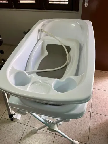 Carrinho de bebê com bebê conforto e banheira com trocador de bebê