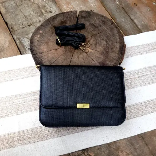 Bolsa preta pequena com alça removível, detalhes em dourado e fecho magnético e zíper
