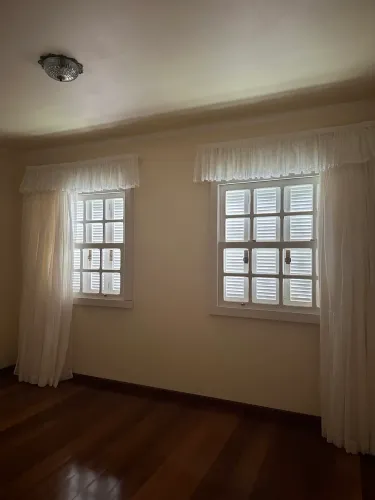 Janela veneziana de madeira com parte interna de vidro quadriculado 