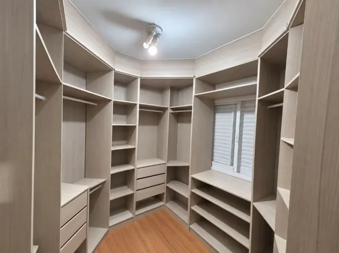Closet com gaveteiros, cabideiros e sapateira.