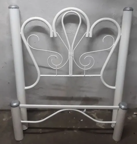 Cama em cor branca com retoques na pintura.