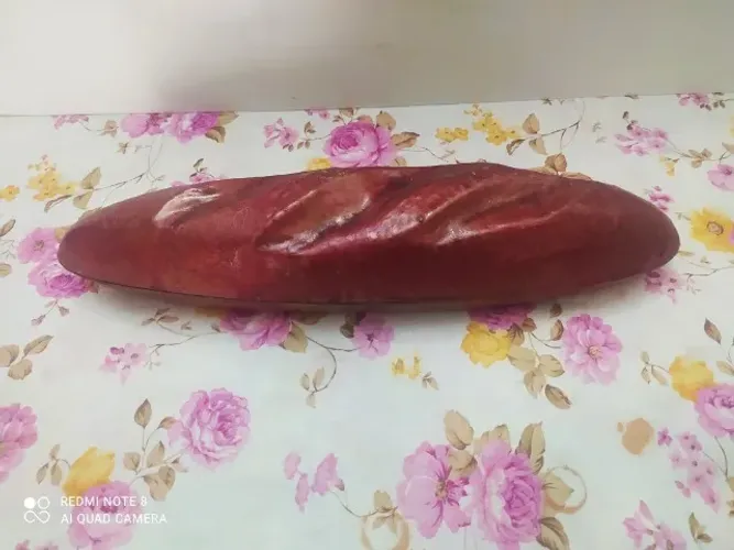 Porta objetos de metal em formato de baguete.