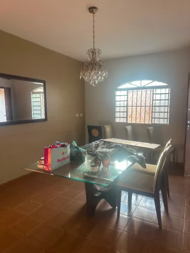 Mesa vidro e pés e cadeiras em madeira 