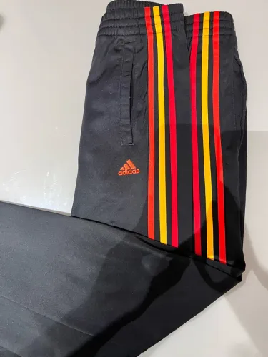 Calça esporte adidas sem detalhes. Pouco uso. Está perfeito listras vermelhas e amarelas.