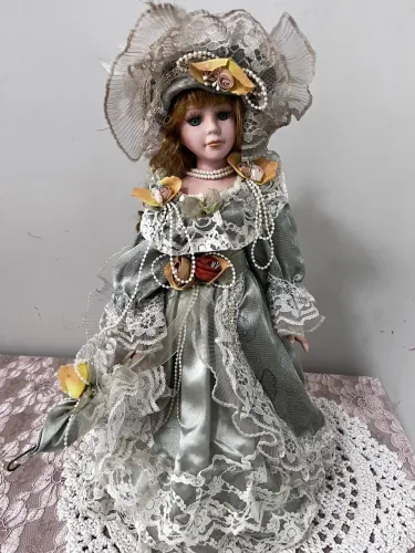 Boneca de porcelana dama antiga roupa de época verde.