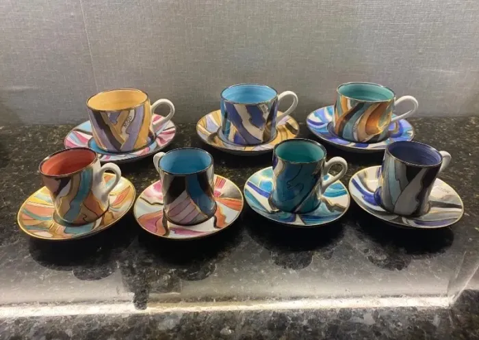 Conjunto de xícaras de chá e café coloridas com detalhes dourados.