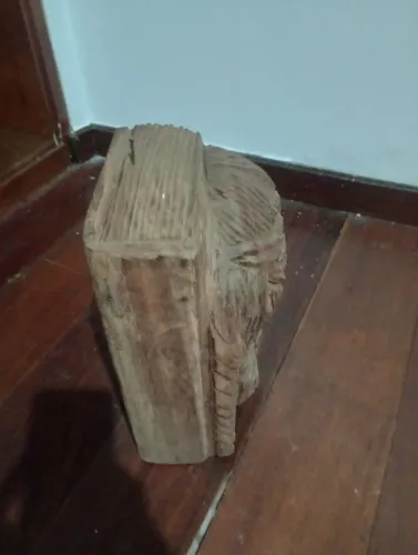 Escultura de bíblia com rosto de Cristo entalhado na madeira