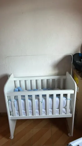 Berço de bebê branco com rodinhas e kit berço