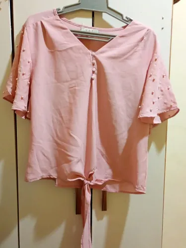 Linda blusa rosa com detalhes em pérolas nas mangas e amarração frontal.