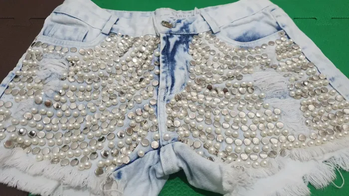 Short jeans destroyed com pedrarias