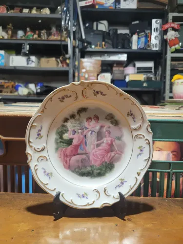 Prato decorativo em porcelana apresenta uma clássica cena galante policromada ao centro