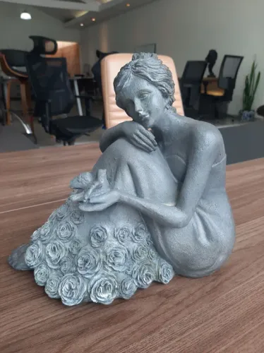 Linda escultura de mulher sentada com pássaro
