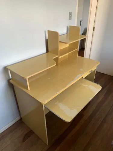 Escrivaninha de madeira com prateleiras e gaveta, ideal para estudo ou home office.