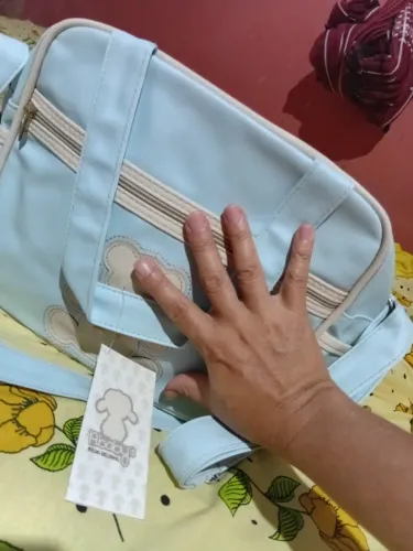 Uma bolsa nova de bebê recém-nascido acabando umas roupinhas no valor de R$ 50 