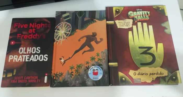 3 livros juntos diário gravity falls, olhos prateados, pantera Negra.