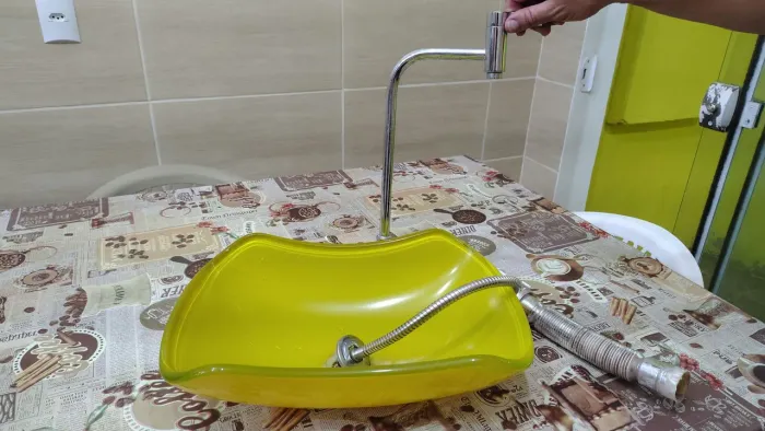 Pia amarela de vidro, torneira e Cifão
