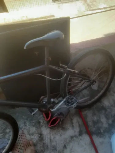 Vende-se bicicleta preta com um tempo de uso, mais em bom estado de conservação 