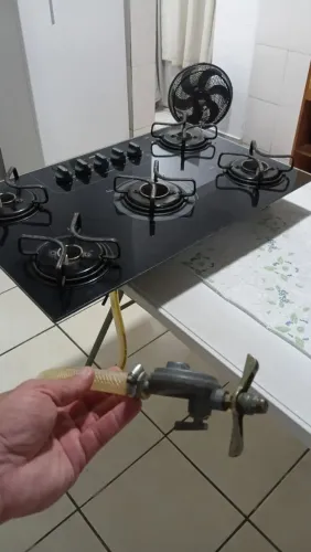 Fogão de 5 bocas com mesa de vidro preta.