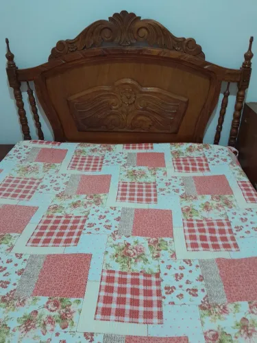 Cama casal colonial em cerejeira com mesa de cabeceira e espelho.