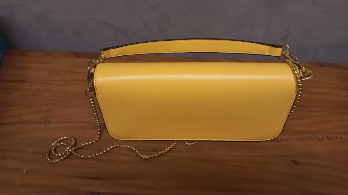 Bolsa  tiracolo amarela, modelo Valentino, com logo V, fecho magnético,  couro sintético.