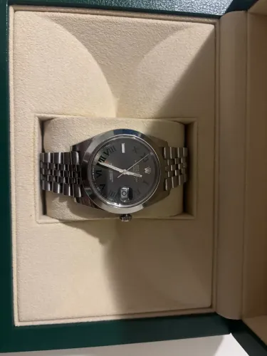O relógio na imagem é um Rolex Datejust 41, com caixa e pulseira Jubilee 