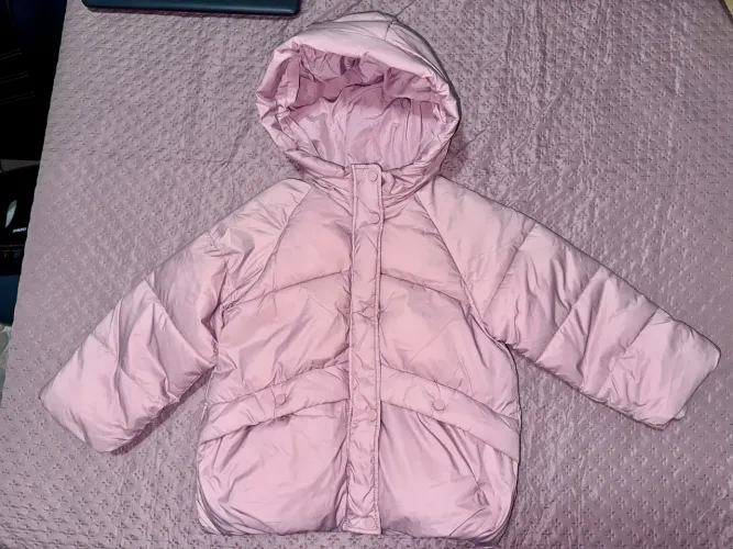 O item selecionado é um casaco puffer com capuz infantil em tom rosa, da Zara 