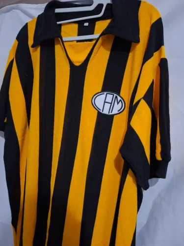 Camisa retrô do Atlético Mineiro com emblema CAM na frente e distintivo de comemoração 100